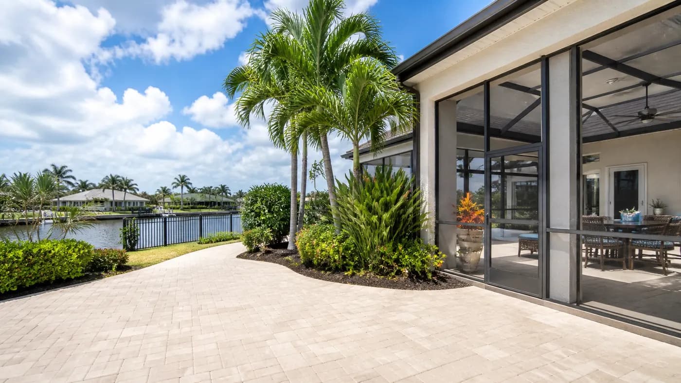 Illustrative waterfront patio and screened outdoor living area with palms